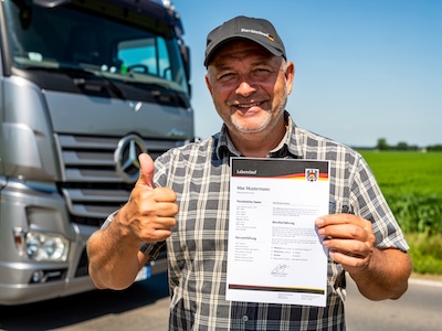 Ein LKW-Fahrer der seinen Lebenslauf den er mit 12Bewerbung.de erstellt hat in der Hand hält. Neben seinem LKW stehend, auf einer hellen Landstraße.